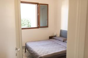 ein kleines Schlafzimmer mit einem Bett und einem Fenster in der Unterkunft Villa Julia, magia del sud in Sampieri