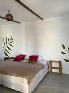 a bedroom with a bed with red and green pillows at Indiana Kite school and Hostel in Cumbuco
