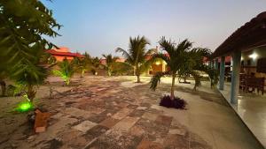 a courtyard with palm trees in a resort at Casa Pierot in Luis Correia