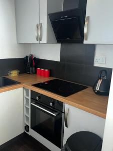 una cucina con piano cottura e piano di lavoro di Frobisher Apartment a Erith