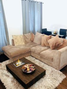 a living room with a couch and a table at Frobisher Apartment in Erith