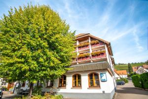 a building with a tree in front of it at Hotel Restaurant Lamm Hebsack in Remshalden