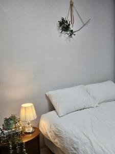 a bedroom with a bed and a table with a lamp at macity in Incheon