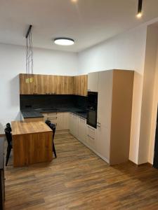 a kitchen with white cabinets and a wooden table at Apartmány Ružomberok in Ružomberok