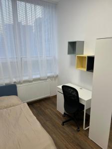 a bedroom with a desk and a bed and a bed and a desk at Apartmány Ružomberok in Ružomberok
