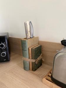 un par de libros sentados en un estante con un cuchillo en Gite de Beaufournier, en Avremesnil