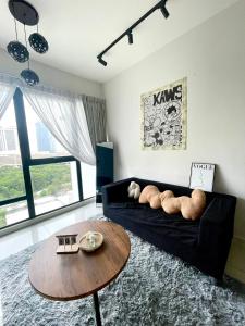 a living room with a black couch and a table at MidValley SouthKey Mosaic Tower B in Johor Bahru