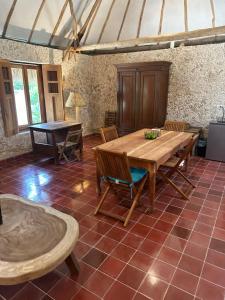 uma sala de jantar com uma mesa de madeira e cadeiras em Hacienda Guesthouse with Private Cenote em Espita