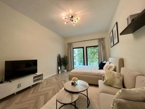 a large living room with a bed and a television at Luxury Modern Studio I Discovery Gardens in Dubai