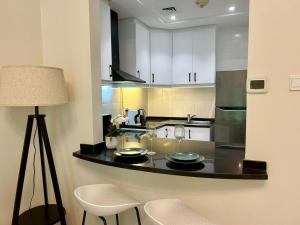 a kitchen with a counter with two wine glasses on it at Luxury Modern Studio I Discovery Gardens in Dubai