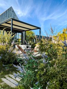 um jardim com flores roxas e um edifício em Sauvage em Quiberon