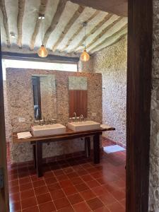 uma casa de banho com três lavatórios e dois espelhos em Hacienda Guesthouse with Private Cenote em Espita