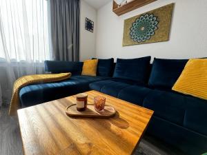 a living room with a blue couch and a coffee table at Apartmán PiccolaDuo v Banskej Bystrici in Banská Bystrica