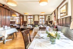 een eetkamer met witte tafels en stoelen bij Hotel Restaurant Lamm Hebsack in Remshalden