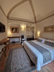アッシジにあるSuite Assisiのベッドルーム(大型ベッド1台、テーブル付)