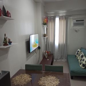 a living room with a couch and a tv on a wall at Cainta Condominium SMDC CHARM in Manila
