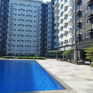 ein Schwimmbad vor zwei hohen Gebäuden in der Unterkunft Cainta Condominium SMDC CHARM in Manila