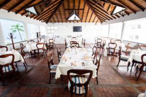 uma sala de jantar com mesas e cadeiras brancas em Hotel Guane em Bucaramanga