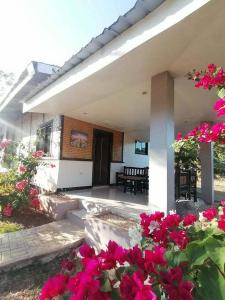 a patio with pink flowers in front of a house at Banlaw Garden Resort in Puerto Princesa City