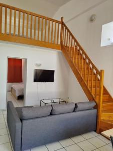 - un salon avec un canapé et un escalier dans l'établissement Spacieuse et confortable maison avec garage, à Anzin