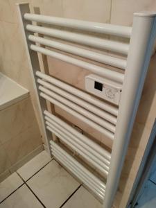 un radiateur blanc dans une salle de bains à côté d'un sol carrelé dans l'établissement Spacieuse et confortable maison avec garage, à Anzin