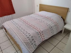 - un lit avec une couverture rose et blanche dans l'établissement Spacieuse et confortable maison avec garage, à Anzin
