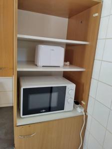 un four micro-ondes installé sur une étagère dans une cuisine dans l'établissement Spacieuse et confortable maison avec garage, à Anzin