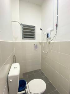 La salle de bains est pourvue d'une douche et de toilettes. dans l'établissement Uzma Homestay Kuala Sg Baru, Melaka, à Malacca