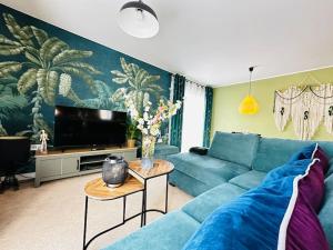 a living room with a blue couch and a tv at Cosy apartment at the marina in Portishead