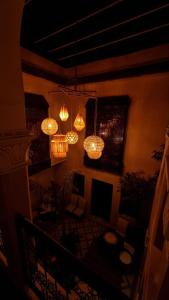 a living room with chandeliers hanging from the ceiling at Dar Tuscia in Marrakech