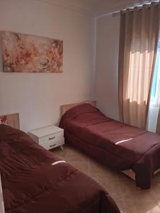 a bedroom with two beds and a window at Bel appartement proche de la mer Hammamet in Hammamet