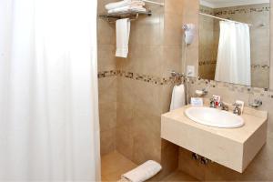 y baño con lavabo y ducha. en Hotel Intersur San Telmo en Buenos Aires