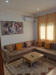 ein Wohnzimmer mit einem Sofa und einem Couchtisch in der Unterkunft Bel appartement proche de la mer Hammamet in Hammamet