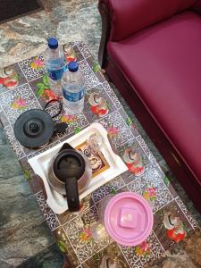 - une table avec des bouteilles d'eau et des assiettes sur un canapé dans l'établissement Guru Residency Pondicherry, à Pondichéry