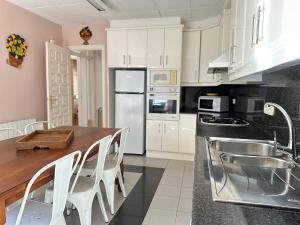 a kitchen with a wooden table and white cabinets at Agi Riu Segre Villa in Roses
