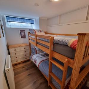 two bunk beds in a room with a window at Ryde Beach Garden Apartment in Ryde