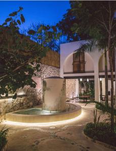 a building with a fountain in the middle of a courtyard at TreeHouse Boutique Hotel, an adults only boutique hotel in Mérida