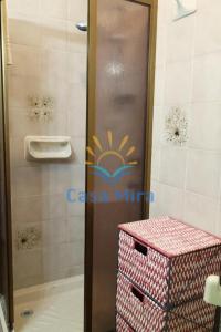 a shower with a glass door with a pink stool in a bathroom at Mira Holiday Apartment Chia in Chia