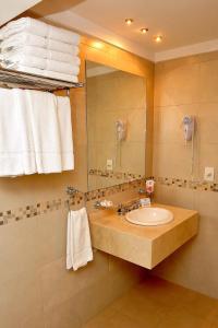 a bathroom with a sink and a mirror and towels at Hotel Intersur San Telmo in Buenos Aires