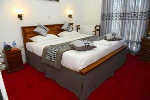 a bedroom with a large bed with white sheets and pillows at The Royal Terrace Holiday Bungalow in Nuwara Eliya