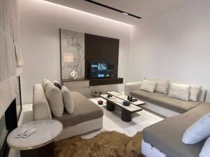 a living room with a couch and a tv at Appartement Californien in Sidi Daoud
