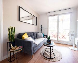 uma sala de estar com um sofá e duas mesas em Le Richter - terrasse à Port Marianne em Montpellier
