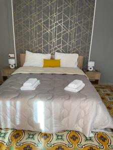 duże łóżko z dwoma ręcznikami na górze w obiekcie Privilge Gzira w Gżirze