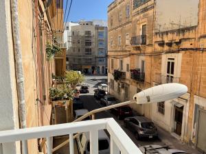 uma vista para a rua a partir de uma varanda com uma luz de rua em Privilge Gzira em Il-Gżira