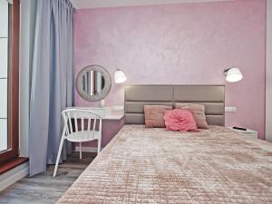 a bedroom with a large bed with a pink wall at City Center - Riverside by Apartmore in Gdańsk