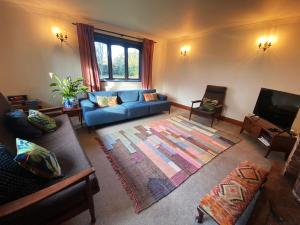 a living room with a blue couch and a television at Rivendell in Diss