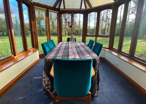 a dining room with a table and chairs and windows at Rivendell in Diss
