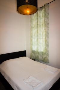 a bedroom with a white bed with a window at L'amoureux - terrasse et climatisation coeur de ville in Montpellier