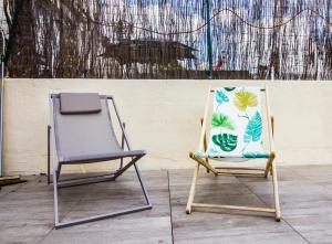 モンペリエにあるL'amoureux - terrasse et climatisation coeur de villeの壁の前に隣り合わせの椅子2脚