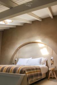 una camera da letto con un grande letto con un arco sopra di esso di Nomad Houses - Casa Sarilho a Beja